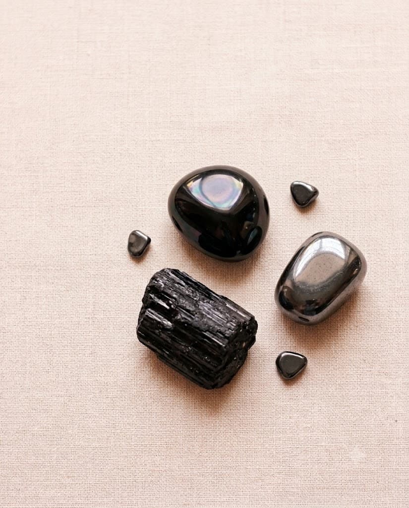 Black tourmaline, obsidian and hematite on bone, softly lit